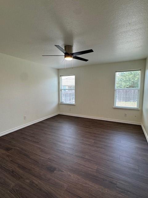 5511 Toledo Farm, San Antonio, TX 78222 - empty room with healthy amount of natural light, dark wood-style flooring, baseboards, a ceiling fan, and a textured ceiling