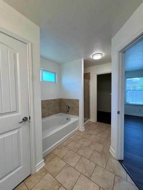 5511 Toledo Farm, San Antonio, TX 78222 - full bathroom featuring a shower stall, healthy amount of natural light, a garden tub, and tile patterned floors