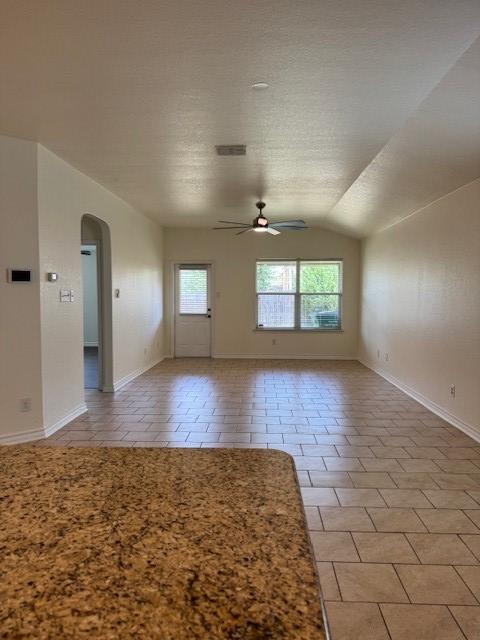 5511 Toledo Farm, San Antonio, TX 78222 - spare room featuring plenty of natural light, a ceiling fan, arched walkways, lofted ceiling, and light tile patterned floors
