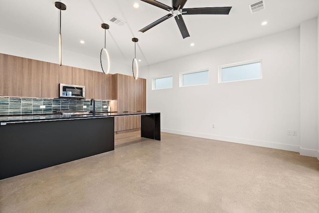 1711 E M Franklin Ave Unit 1, Austin, TX 78721 - kitchen featuring stainless steel microwave, modern cabinets, dark countertops, recessed lighting, and backsplash