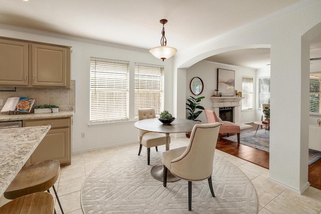 13413 Bolivia Dr, Austin, TX 78729 - dining space featuring ornamental molding, light tile patterned floors, arched walkways, a fireplace, and baseboards