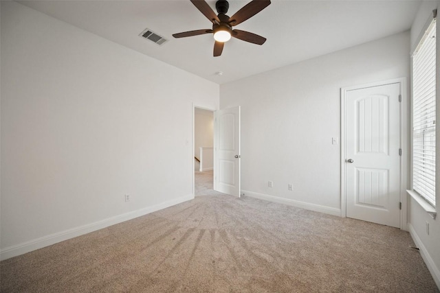 206 Skinner, Kyle, TX 78640 - unfurnished bedroom with light carpet, multiple windows, and baseboards