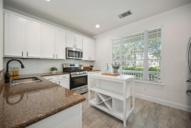 206 Skinner, Kyle, TX 78640 - kitchen featuring stainless steel appliances, a sink, open shelves, backsplash, and recessed lighting