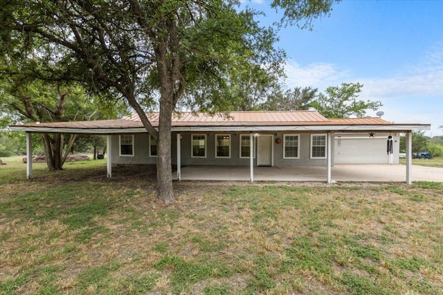 7406 Nez Perce Trce, Manor, TX 78653 - rear view of property featuring a yard, concrete driveway, a garage, an attached carport, and metal roof