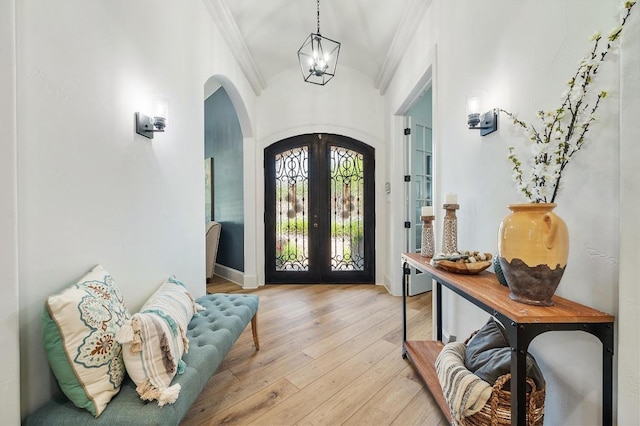 7 Sunview Rd, The Hills, TX 78738 - foyer entrance featuring arched walkways, ornamental molding, french doors, light wood-style floors, and a chandelier