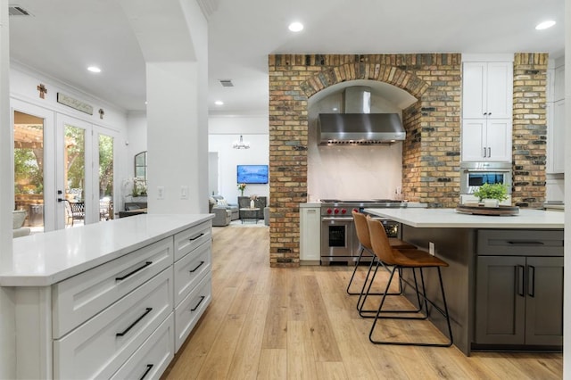 7 Sunview Rd, The Hills, TX 78738 - kitchen featuring stainless steel appliances, a kitchen island, white cabinetry, tasteful backsplash, and light countertops