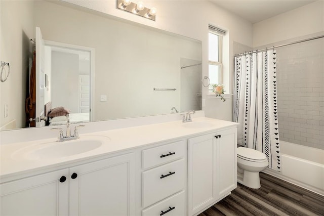 7613 Frida Bnd, Austin, TX 78744 - bathroom featuring toilet, wood finished floors, double vanity, and shower / tub combo with curtain