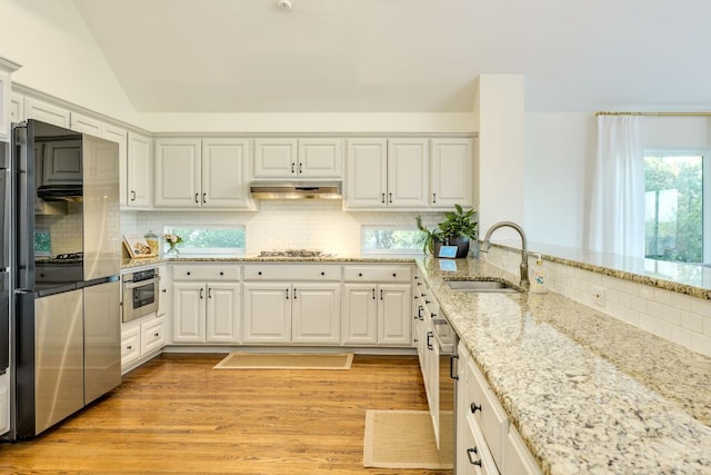 5801 Fox Chapel Dr, Austin, TX 78746 - kitchen with a sink, backsplash, stainless steel appliances, light stone counters, and under cabinet range hood