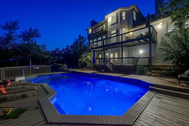 5801 Fox Chapel Dr, Austin, TX 78746 - pool at twilight featuring stairway, a deck, and an outdoor pool