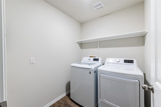6100 Shanjia Dr, Austin, TX 78724 - laundry room with washing machine and clothes dryer, dark wood-style flooring, and baseboards