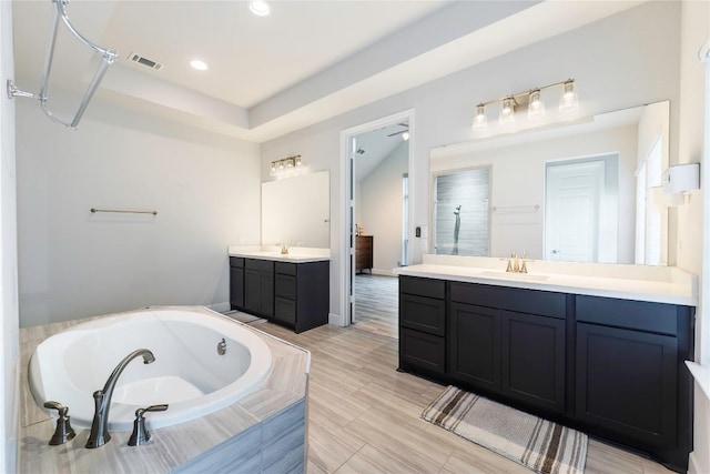 817 Craven Hill Ln, Leander, TX 78641 - bathroom featuring two vanities, a whirlpool tub, and recessed lighting