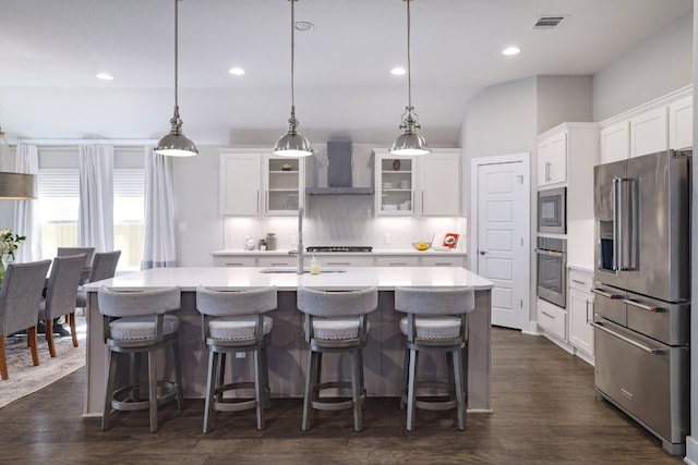 132 Lockhart Dr, Liberty Hill, TX 78642 - kitchen with stainless steel appliances, wall chimney exhaust hood, backsplash, light countertops, and a center island with sink