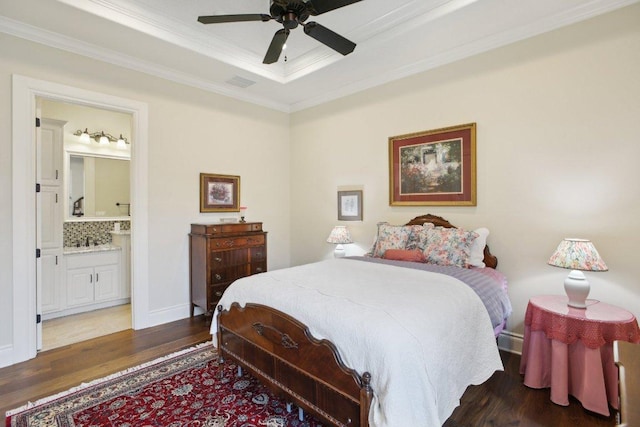 1353 Osprey Ridge Loop, Lago Vista, TX 78645 - bedroom featuring wood finished floors, ornamental molding, a tray ceiling, connected bathroom, and a ceiling fan