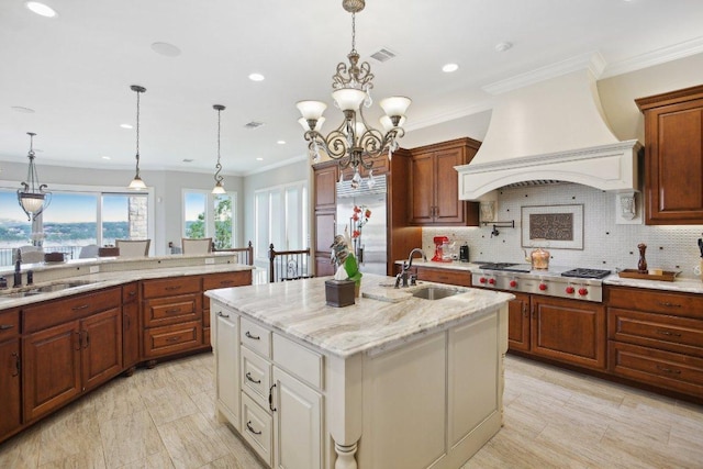 1353 Osprey Ridge Loop, Lago Vista, TX 78645 - kitchen with stainless steel gas stovetop, a sink, custom exhaust hood, a center island with sink, and crown molding