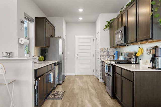7818 Moody Bnd, Austin, TX 78744 - kitchen featuring stainless steel appliances, dark brown cabinets, tasteful backsplash, light countertops, and recessed lighting