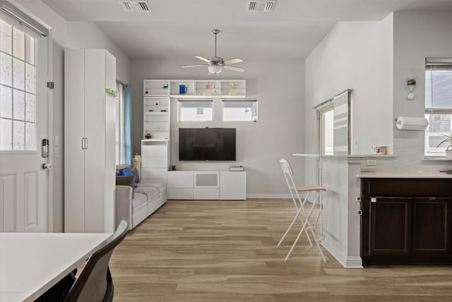 7818 Moody Bnd, Austin, TX 78744 - kitchen featuring light wood-style floors, dark brown cabinetry, a ceiling fan, light countertops, and baseboards