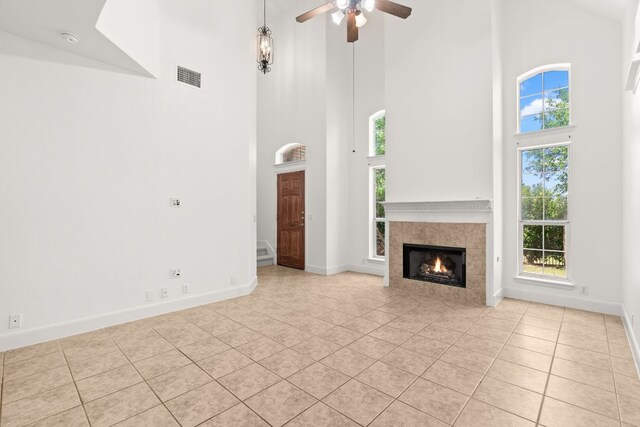 14812 Avery Ranch Blvd Unit 72, Austin, TX 78717 - unfurnished living room featuring a towering ceiling, light tile patterned flooring, ceiling fan, a fireplace, and baseboards