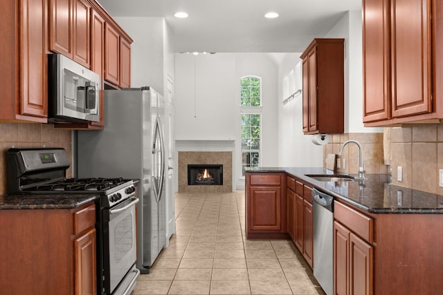 14812 Avery Ranch Blvd Unit 72, Austin, TX 78717 - kitchen featuring appliances with stainless steel finishes, a sink, dark stone counters, light tile patterned floors, and tasteful backsplash