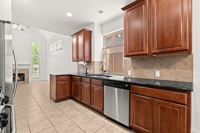 14812 Avery Ranch Blvd Unit 72, Austin, TX 78717 - kitchen featuring stainless steel appliances, a sink, light tile patterned flooring, tasteful backsplash, and a tiled fireplace