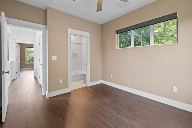1500 Justin Ln Unit 2, Austin, TX 78757 - unfurnished bedroom featuring dark wood finished floors, baseboards, ensuite bath, and a ceiling fan