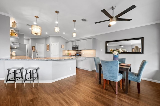 4600 Tello Path, Austin, TX 78749 - kitchen featuring crown molding, a ceiling fan, dark wood-type flooring, tasteful backsplash, and a peninsula
