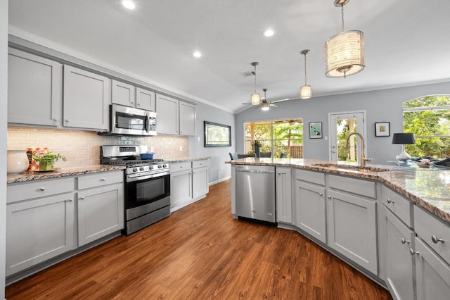 4600 Tello Path, Austin, TX 78749 - kitchen with stainless steel appliances, gray cabinets, vaulted ceiling, plenty of natural light, and backsplash