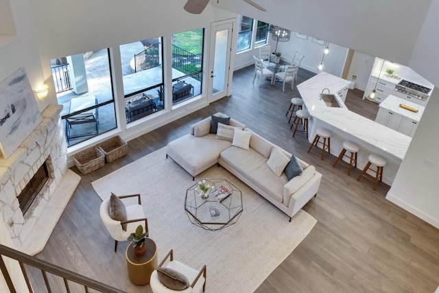 13601 Montview Dr, Austin, TX 78732 - living room featuring wood finished floors, a stone fireplace, baseboards, and ceiling fan