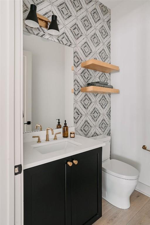 2209 Woodland Ave Unit 301, Austin, TX 78741 - bathroom featuring vanity, toilet, and wood finished floors