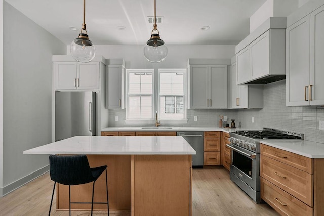 2209 Woodland Ave Unit 301, Austin, TX 78741 - kitchen with high quality appliances, a sink, a center island, decorative backsplash, and light wood-type flooring