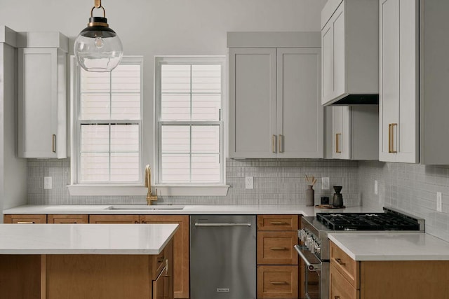 2209 Woodland Ave Unit 301, Austin, TX 78741 - kitchen with stainless steel appliances, a sink, decorative backsplash, brown cabinetry, and pendant lighting