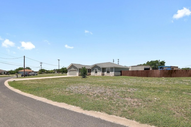 131 Roundup Dr, Liberty Hill, TX 78642 - ranch-style house with driveway, stone siding, and an attached garage