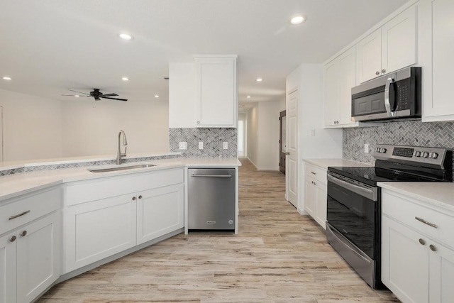 131 Roundup Dr, Liberty Hill, TX 78642 - kitchen with appliances with stainless steel finishes, a sink, backsplash, recessed lighting, and white cabinetry