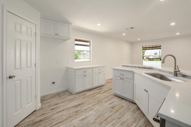 131 Roundup Dr, Liberty Hill, TX 78642 - kitchen featuring a sink, light wood finished floors, white cabinets, recessed lighting, and baseboards