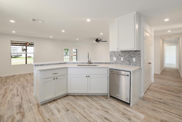 131 Roundup Dr, Liberty Hill, TX 78642 - kitchen featuring stainless steel dishwasher, a sink, light countertops, light wood finished floors, and recessed lighting