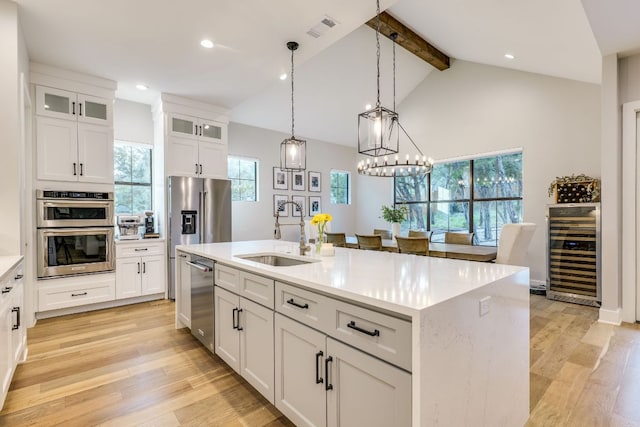 5904 Hudson Bend Rd, Austin, TX 78734 - kitchen featuring wine cooler, stainless steel appliances, a sink, beamed ceiling, and light wood finished floors