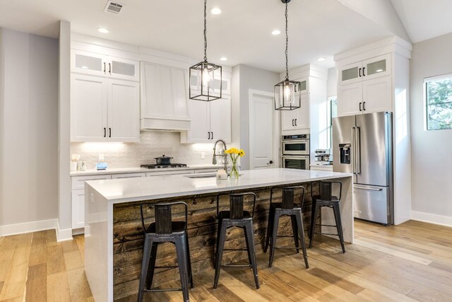 5904 Hudson Bend Rd, Austin, TX 78734 - kitchen featuring appliances with stainless steel finishes, baseboards, a kitchen island with sink, light countertops, and light wood finished floors