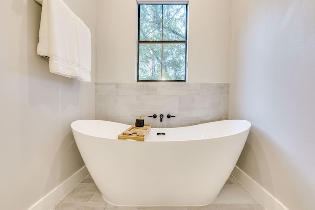5904 Hudson Bend Rd, Austin, TX 78734 - full bath with tile walls, a freestanding tub, tile patterned floors, baseboards, and wainscoting