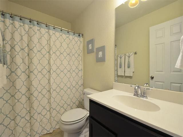 9944 Wading Pool Path, Austin, TX 78748 - bathroom featuring toilet, vanity, and curtained shower