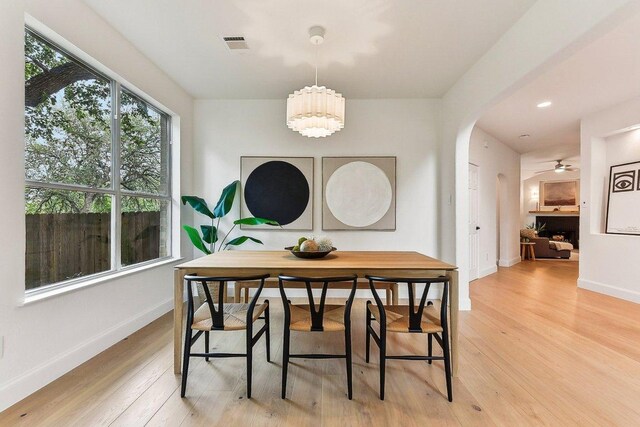 9123 La Siesta Bnd, Austin, TX 78749 - dining room featuring light wood finished floors, arched walkways, baseboards, and a chandelier