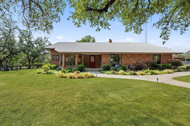 423 County Road 1010, Lampasas, TX 76550 - ranch-style home featuring a front yard, a chimney, brick siding, and metal roof