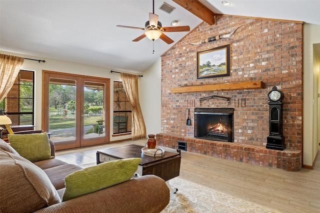 423 County Road 1010, Lampasas, TX 76550 - living room featuring wood finished floors, a brick fireplace, ceiling fan, beamed ceiling, and french doors