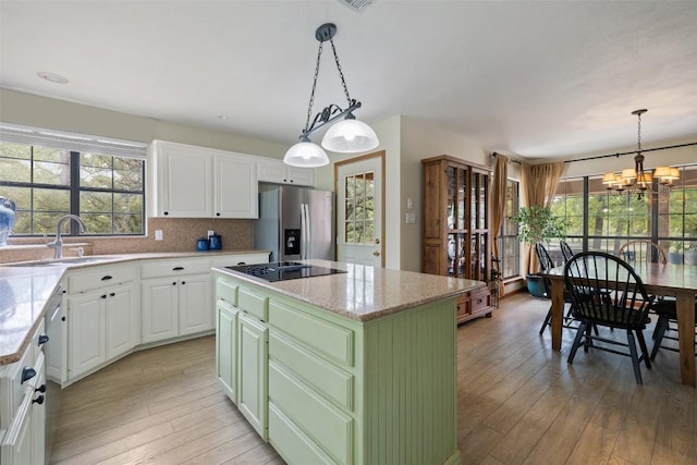 423 County Road 1010, Lampasas, TX 76550 - kitchen with stainless steel refrigerator with ice dispenser, a sink, light wood finished floors, a kitchen island, and white cabinetry