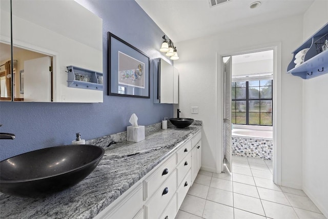 423 County Road 1010, Lampasas, TX 76550 - bathroom with tile patterned floors, baseboards, double vanity, and tiled tub