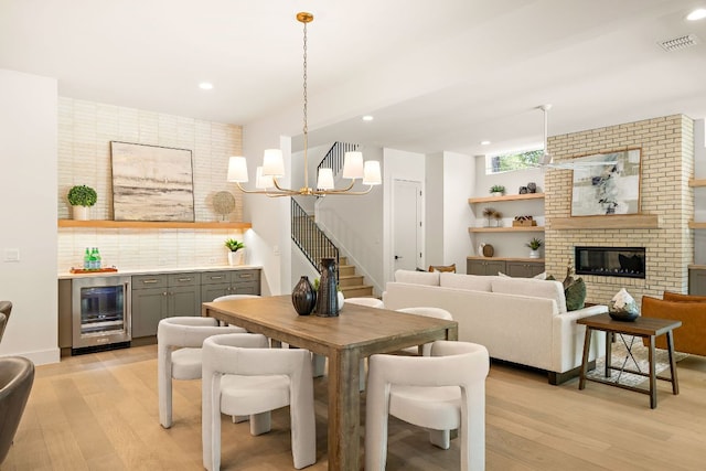 5615 Shoalwood Ave, Austin, TX 78756 - dining space with wine cooler, light wood finished floors, stairs, a dry bar, and a chandelier