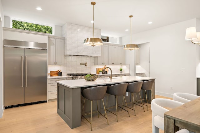 5615 Shoalwood Ave, Austin, TX 78756 - kitchen featuring built in refrigerator, backsplash, light countertops, light wood finished floors, and recessed lighting