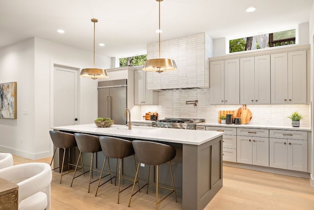 5615 Shoalwood Ave, Austin, TX 78756 - kitchen featuring built in refrigerator, tasteful backsplash, light wood finished floors, a breakfast bar area, and recessed lighting