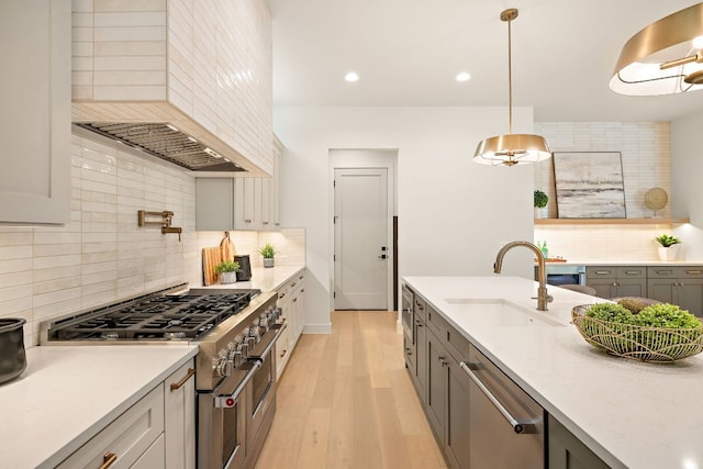 5615 Shoalwood Ave, Austin, TX 78756 - kitchen featuring appliances with stainless steel finishes, a sink, custom exhaust hood, decorative backsplash, and light wood-type flooring