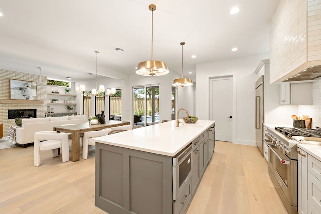 5615 Shoalwood Ave, Austin, TX 78756 - kitchen featuring gray cabinetry, built in appliances, a chandelier, light wood-style flooring, and premium range hood