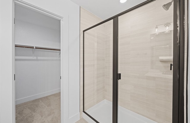 577 Tailwind Dr, Kyle, TX 78640 - full bathroom featuring a stall shower, a walk in closet, and baseboards