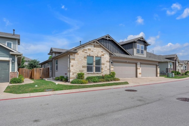 14411 Frankel Loop Unit 32B, Pflugerville, TX 78660 - view of front of property featuring board and batten siding, driveway, stone siding, and a garage